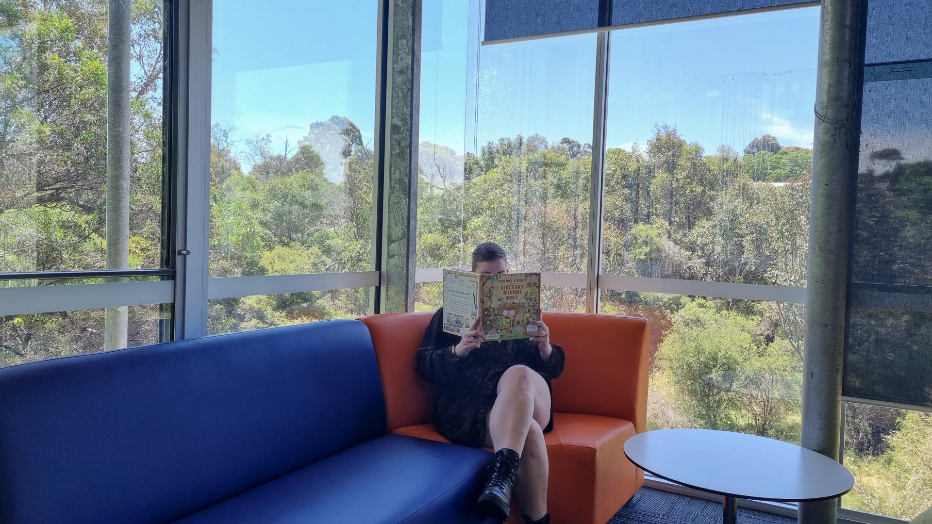 Reading a book on the new library furniture
